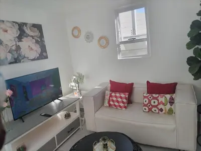 a living room with a couch and a flat screen tv at Cethone Luxury Guest House in Cape Town