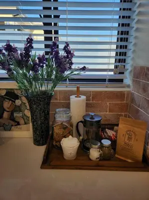 a tray with a candle and a vase with purple flowers at Haus Merwe Self Catering in Cape Town