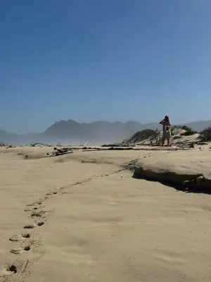a person standing on a beach with footprints in the sand at Sandown Synergy Lagoon House in Hermanus