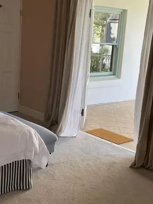 a bedroom with a bed and a open door to a window at Largest one bed apartment & private pool in the Hoek in Franschhoek