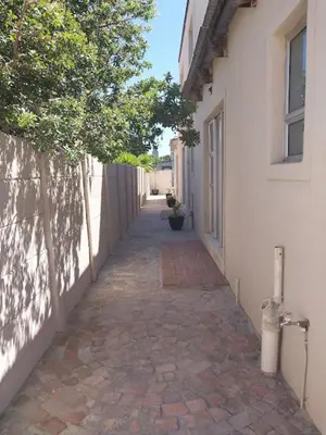 an alley way with a building and a tree at Neptune in Gordonʼs Bay