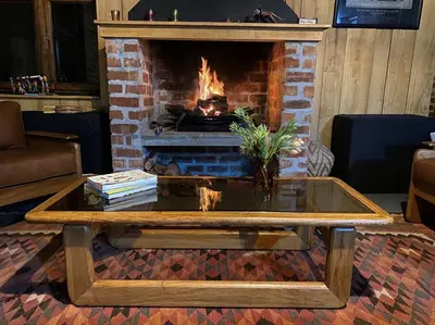 a coffee table in a living room with a fireplace at Underhill Cottage in Breerivier