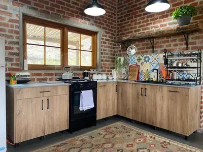 a kitchen with wooden cabinets and a black stove at Underhill Cottage in Breerivier