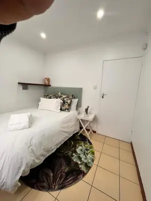 a bedroom with a large bed and a table at 3 Bedroom Family Home with Pool in Cape Town