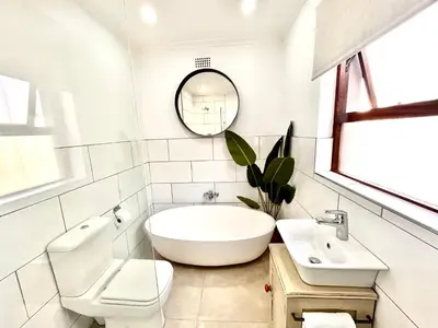 a white bathroom with a tub and a sink at 3 Bedroom Family Home with Pool in Cape Town