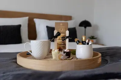 a wooden tray with two coffee cups on a bed at Nine Palms 223B in Cape Town