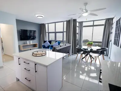 a kitchen and living room with a ceiling fan at St Tropez Beachfront 306 in Strand