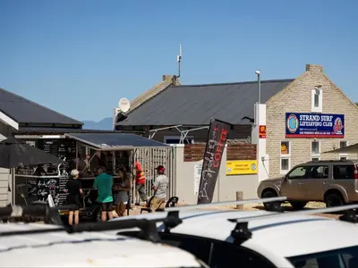 a group of people standing outside of a restaurant at St Tropez Beachfront 306 in Strand