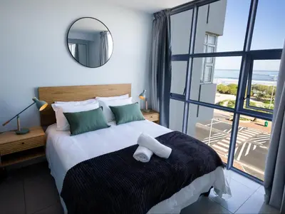 a bedroom with a large bed with a large window at St Tropez Beachfront 306 in Strand