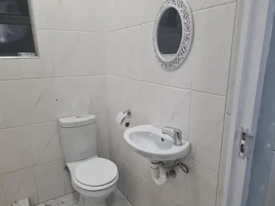 a white bathroom with a toilet and a sink at Michu Guest house in Cape Town
