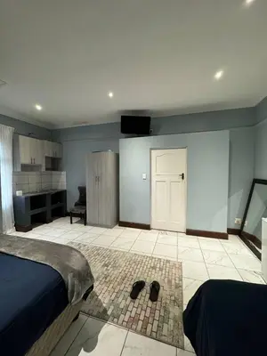a bedroom with a bed and a room with a desk at Michu Guest house in Cape Town