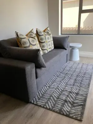 a couch with pillows and a rug in a living room at Songbird D'Aria Cape Town luxury house on Wine Estate in Cape Town