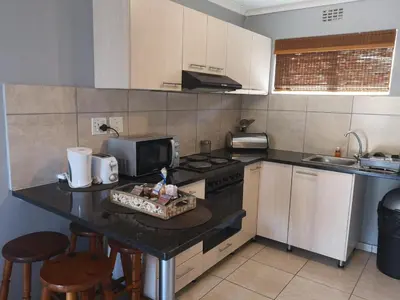 a kitchen with a counter with a stove and a sink at Smithland Centrally Located Accommodation in Cape Town