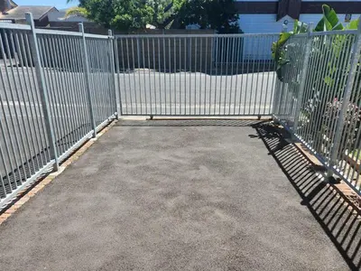 a metal fence with a gate in a driveway at Smithland Centrally Located Accommodation in Cape Town