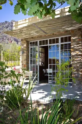 a stone house with a porch with a glass door at Amberg Country Estate in Paarl