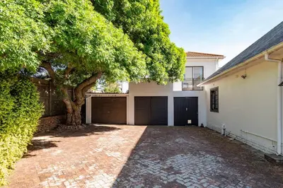 a house with a tree and a brick driveway at Green Haven Apartment in Milnerton in Cape Town