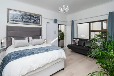 a bedroom with a large bed and a couch at Platinum Haven Aparment in Milnerton in Cape Town