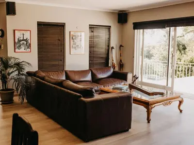 a living room with a leather couch and a coffee table at Cape Select Luxury Accommodation in Durbanville