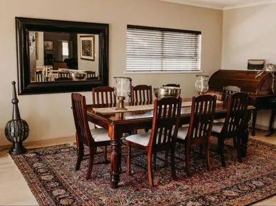 a dining room with a table and chairs and a mirror at Cape Select Luxury Accommodation in Durbanville