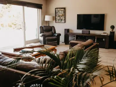 a living room with a couch and a flat screen tv at Cape Select Luxury Accommodation in Durbanville