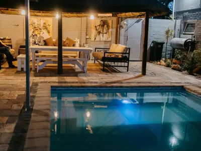 a swimming pool in a yard with a table and a bench at Cape Select Luxury Accommodation in Durbanville