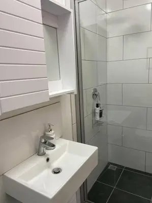 a white bathroom with a sink and a shower at 31Ridge Road in Durbanville
