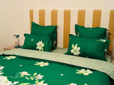 a green bed with green sheets and green pillows at Leisure Lodges selfcatering accommodation Parow in Cape Town
