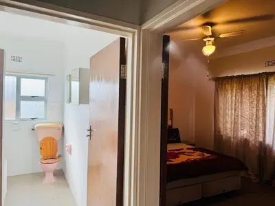 a bathroom with a toilet and a bed in a room at Leisure Lodges selfcatering accommodation Parow in Cape Town
