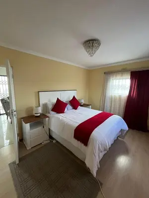 a bedroom with a large bed with red pillows at Alucia in Cape Town