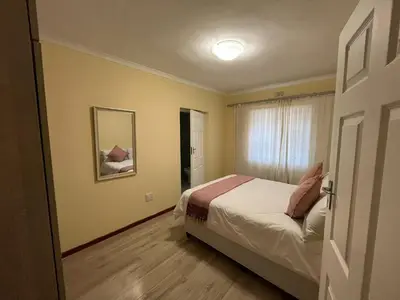 a small bedroom with a bed and a window at Alucia in Cape Town