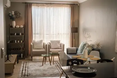 a living room with a couch and a table at Spacious 1 Bedroom Flat Church St Stellenbosch in Stellenbosch