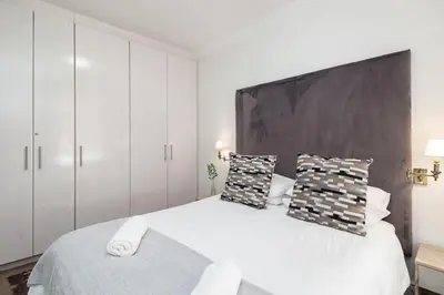 a bedroom with a large white bed with two pillows at Spacious 1 Bedroom Flat Church St Stellenbosch in Stellenbosch