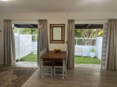a dining room with a table and a mirror at Mozart Close Durbanville- for people who needs space in Durbanville