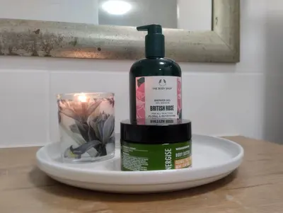 a bottle of alcohol and a candle on a plate at Mozart Close Durbanville- for people who needs space in Durbanville