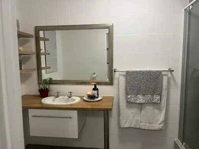 a bathroom with a sink and a mirror at Mozart Close Durbanville- for people who needs space in Durbanville