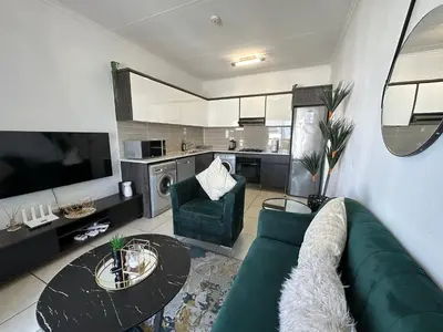 a living room with a green couch and a table at Luxury Stays in Cape Town