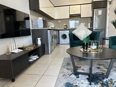 a kitchen and living room with a table and chairs at Luxury Stays in Cape Town