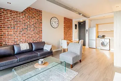 a living room with a couch and a brick wall at 1 bed flat with Mountain view in Cape Town