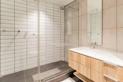 a white bathroom with a sink and a shower at 1 bed flat with Mountain view in Cape Town
