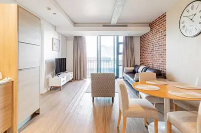 a living room with a table and a living room with a clock at 1 bed flat with Mountain view in Cape Town