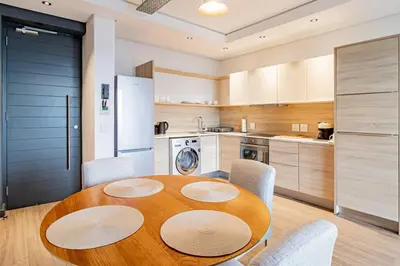 a kitchen with a round wooden table and chairs at 1 bed flat with Mountain view in Cape Town