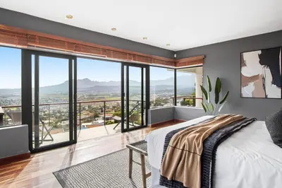 a bedroom with a bed and large windows at Restio View 11 in Cape Town