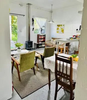 a living room with a table and chairs at Agapanthus garden cottage in Grabouw