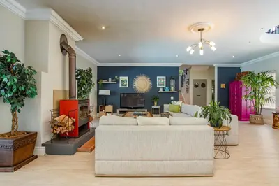 a living room with two white couches and a tv at Luxury Five Bed House in the Heart of Franschhoek in Franschhoek