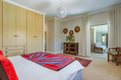 a bedroom with a red blanket on a bed at Luxury Five Bed House in the Heart of Franschhoek in Franschhoek