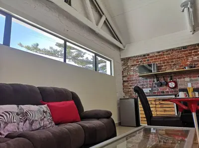 a living room with a couch and a brick wall at Coastal Cozy Home in Cape Town