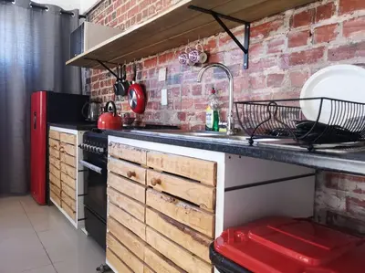a kitchen with a sink and a brick wall at Coastal Cozy Home in Cape Town