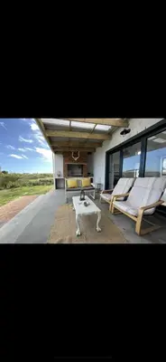 a living room with two chairs and a coffee table at Brunia Cottage in Bettyʼs Bay