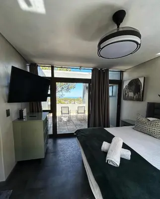 a bedroom with a bed and a flat screen tv at Villa Silver Vos in Hermanus