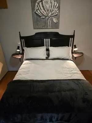 a bed with a black and white comforter and two lamps at Urban Retreat in Cape Town